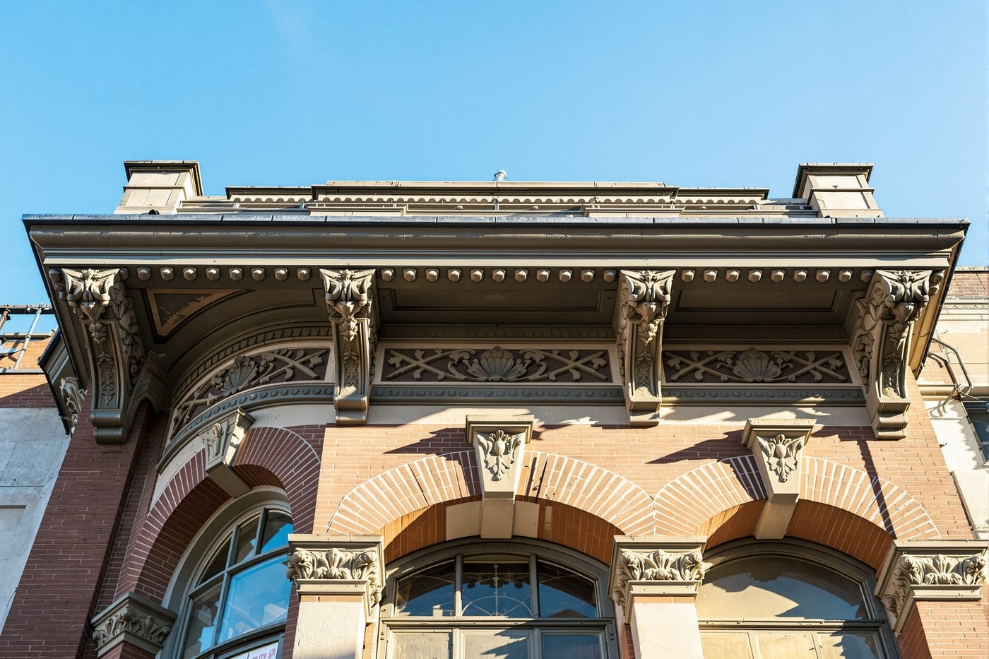 Detail of a decorative pressed-metal cornice and upper-storey brickwork on an old commercial building